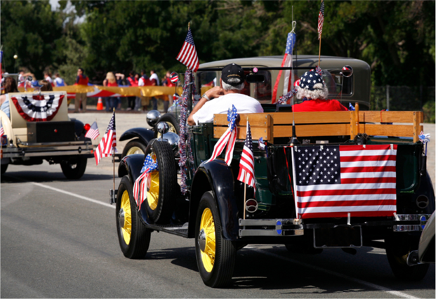 Vintage car in a parade with American flags